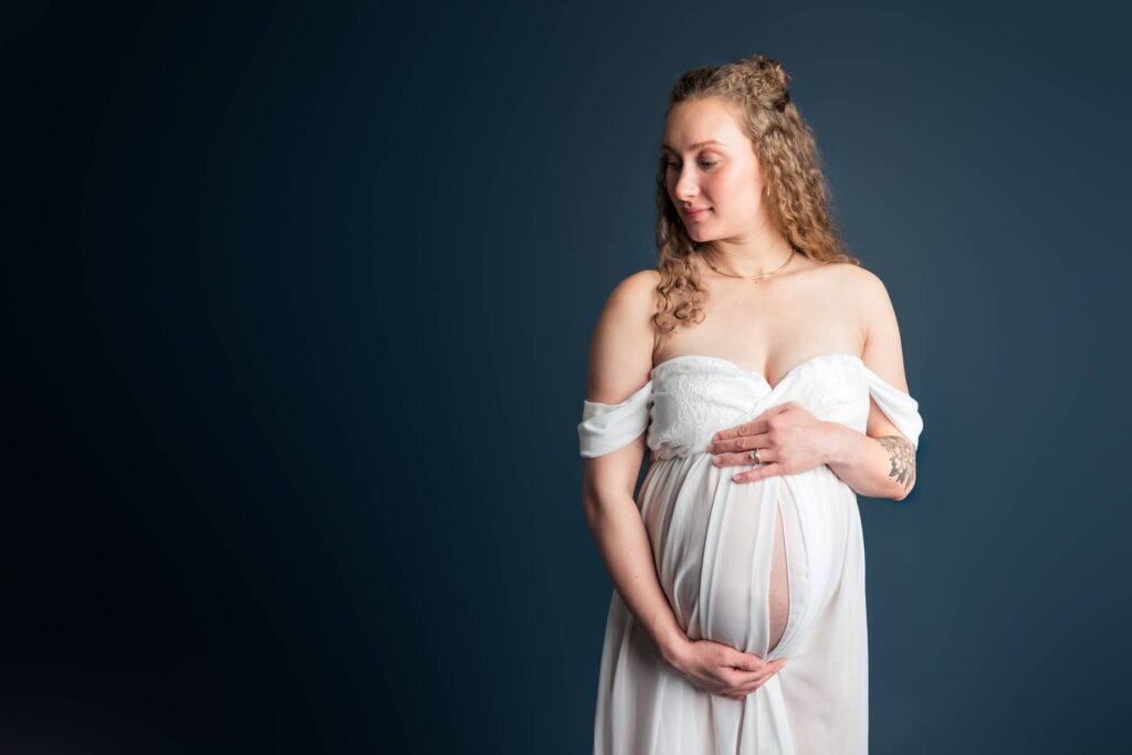 Women poses in beautiful studio maternity photoshoot.  