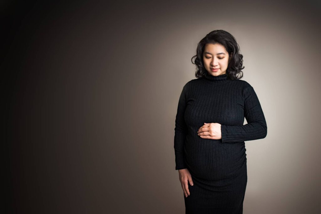 woman wearing a fitted maternity dress for studio photoshoot