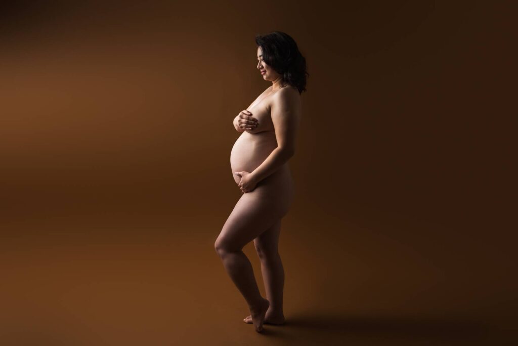 woman posing for fine art nude maternity photoshoot in studio