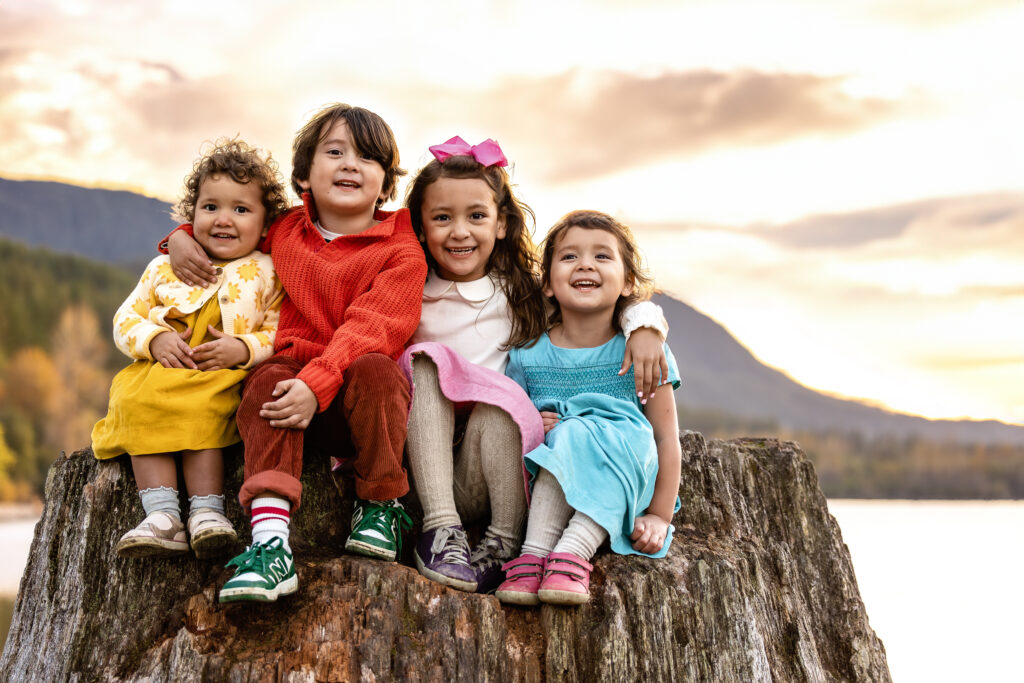 Children sitting on an exposed log embracing at a Family photoshoot at Rattlesnake Lake