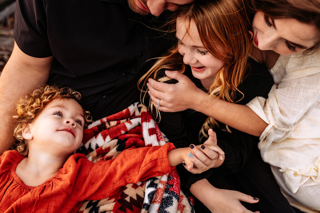 lifestyle family photograph of sisters and mother embracing and holding hands