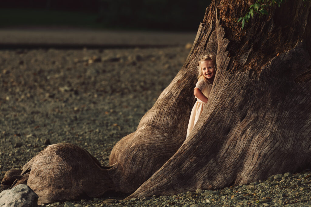 Young playing in driftwood at Rattlesnake Lake during golden hour.