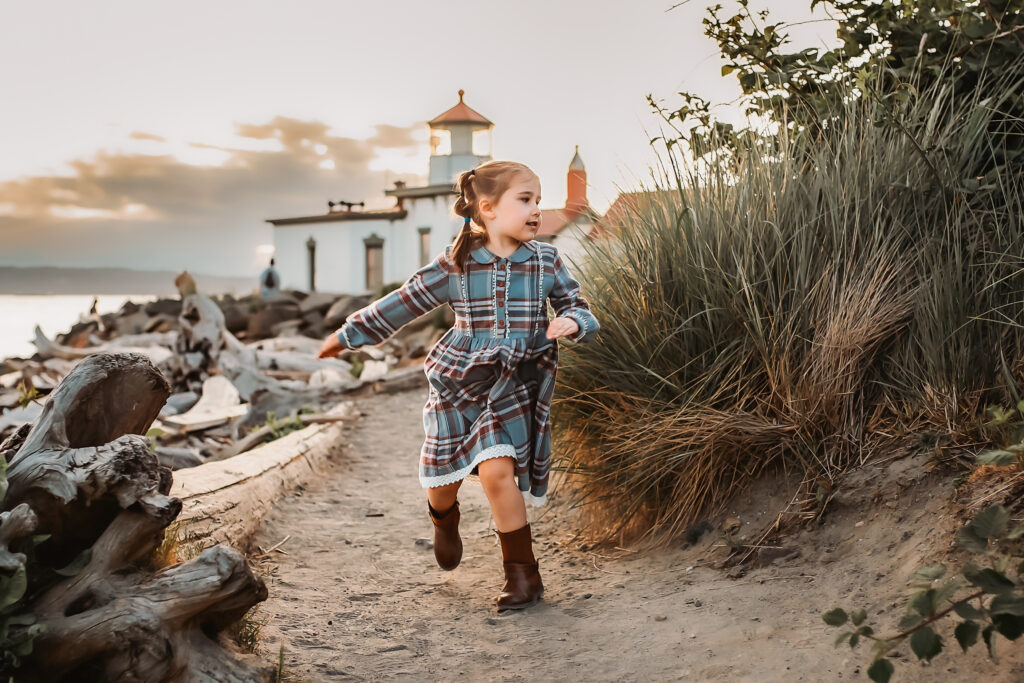 lifestyle family photograph of a young girl running at a scenic beach