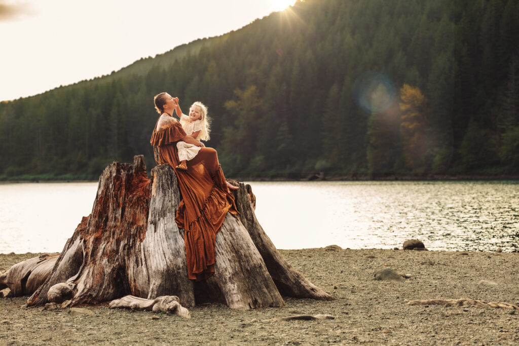 Mother and daughter atop the scenic stumps at the mountain surrounded Rattlesnake Lake.