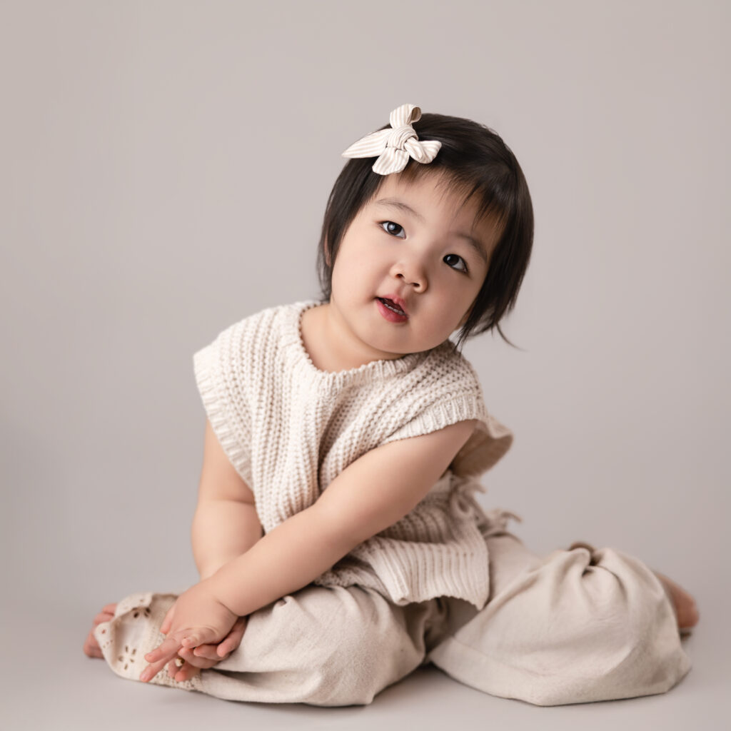 image from bellevue childhood photographer, Telly Dez Photography, of a child moving and wiggling with a curious expression on an ivory backdrop