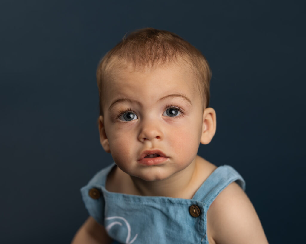 personality portrait of young boy on blue backdrop