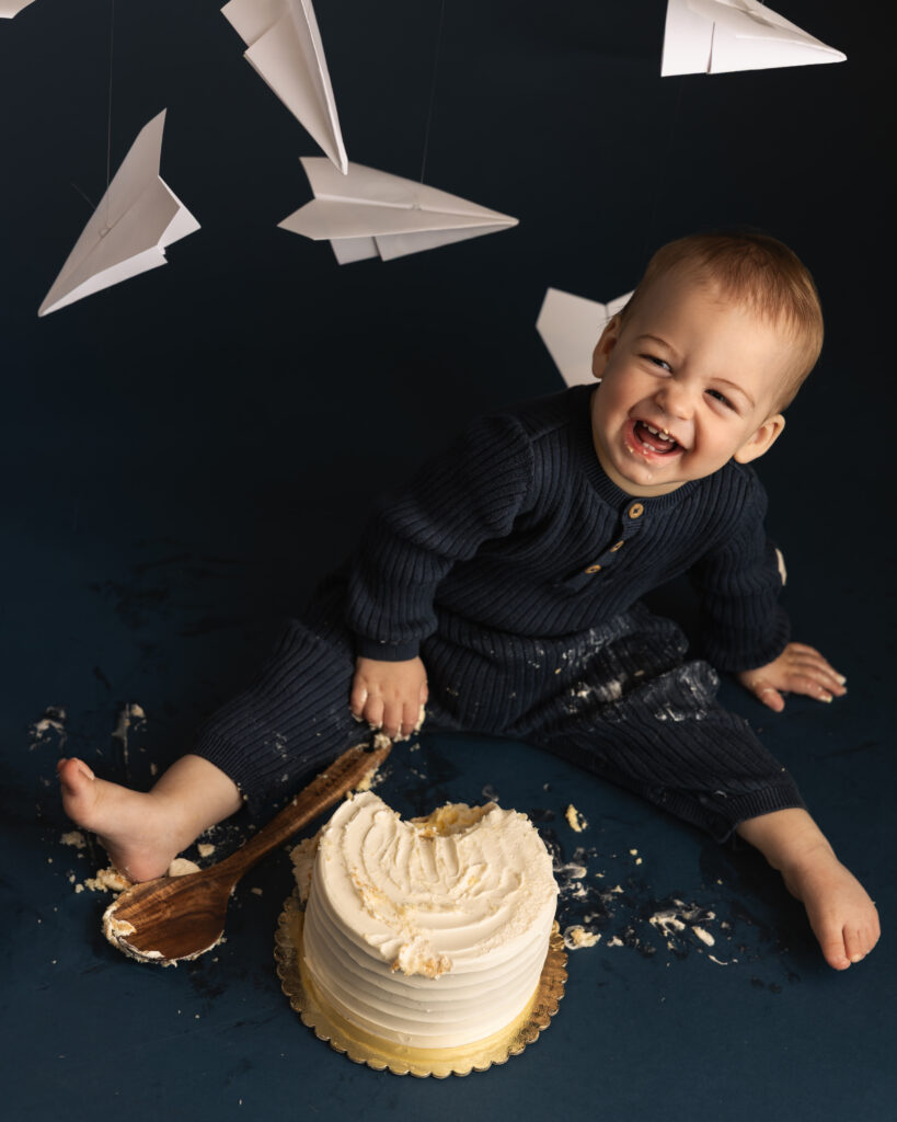 little boy laughing at studio cake smash session