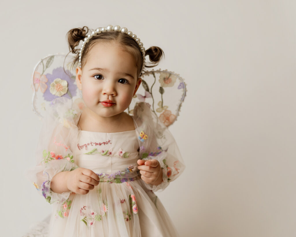 sweet image of a little girl who is wearing a color that coordinates with the background of her studio photography session